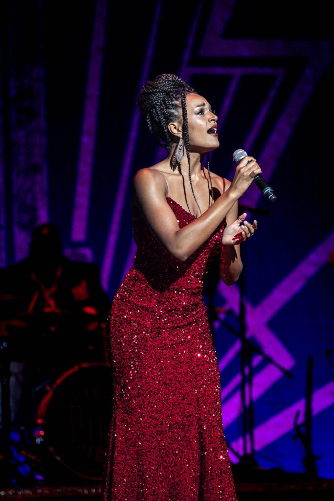 A woman croons to the crowd on stage